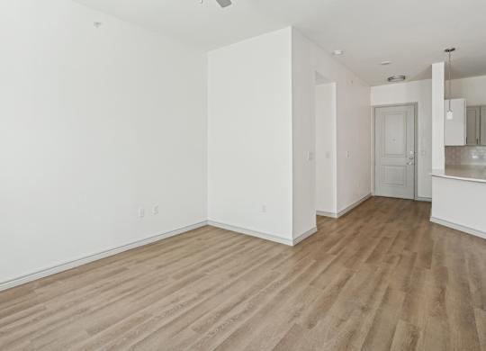 A room with wooden flooring and white walls.