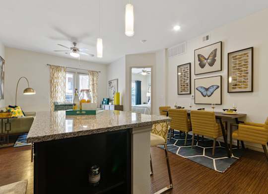 an open kitchen and dining area with a granite counter top and a dining room table