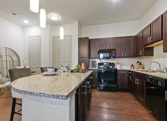 a kitchen with black appliances and a granite counter top