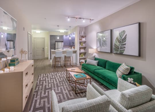 a living room and kitchen with a green couch
