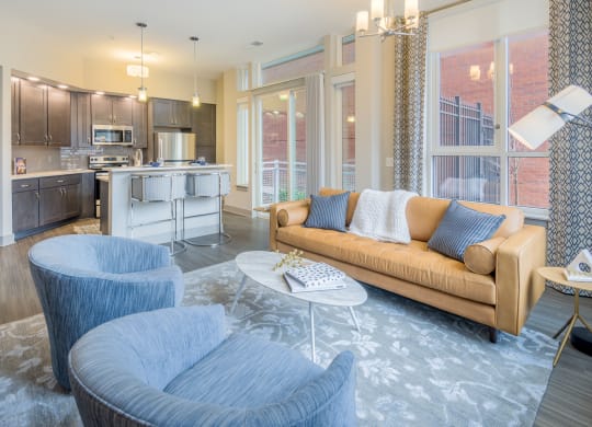 a living room and kitchen with blue chairs and a couch
