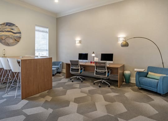 a room with a desk with two computers and a chair