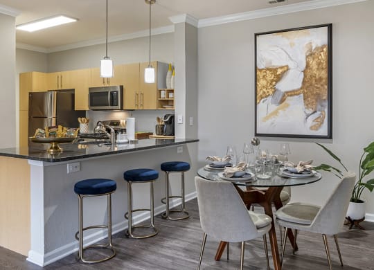 an apartment kitchen and dining area with a table and chairs