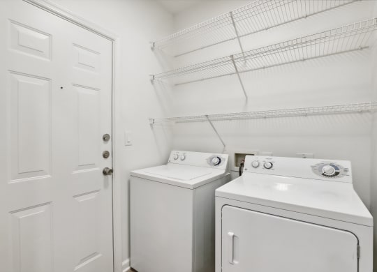 a white washer and dryer in a laundry room with a white door