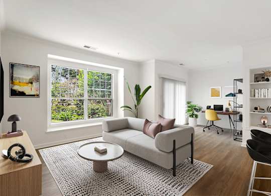 A living room with a white couch and a coffee table in front of a window.