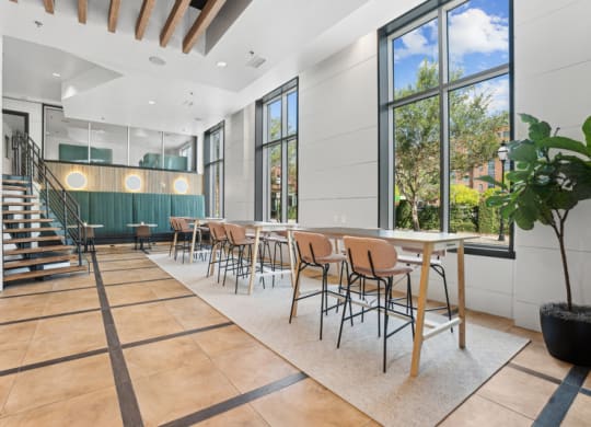 a dining room with tables and chairs and large windows