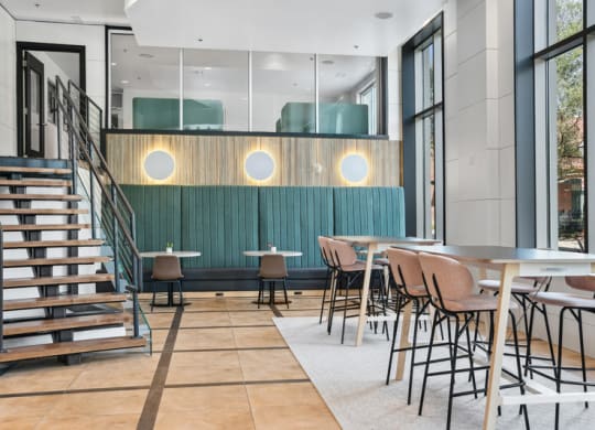 a dining room with tables and chairs and a staircase