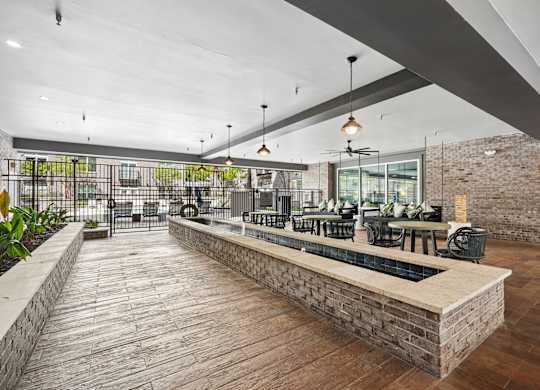 A modern outdoor seating area with a brick wall and wooden flooring.