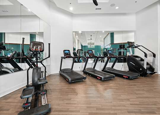 A gym with treadmills and elliptical machines.