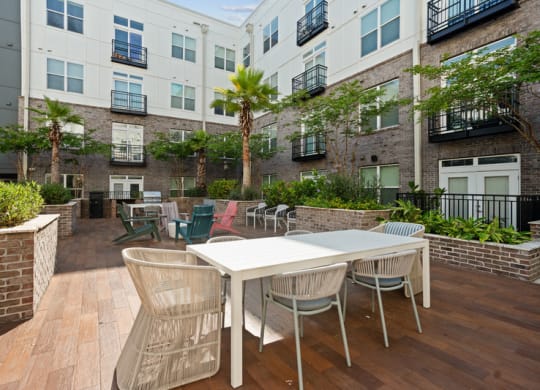an outdoor patio with tables and chairs in an apartment building