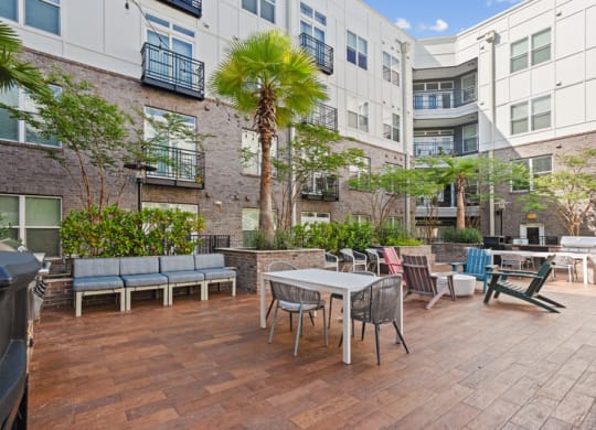 a patio with a table and chairs in front of an apartment building
