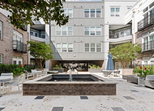 a courtyard with a fountain and tables and chairs