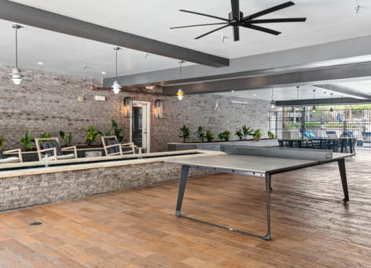 a ping pong table in a lobby with a brick wall