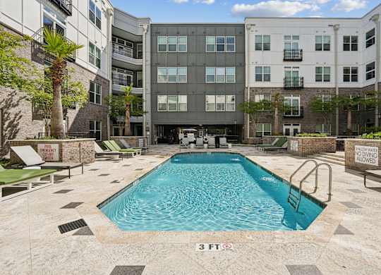 A pool in front of a building with a sign that says 3 feet.
