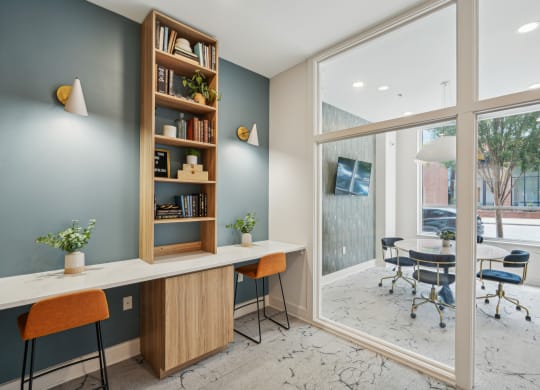 a home office with a desk and a large window
