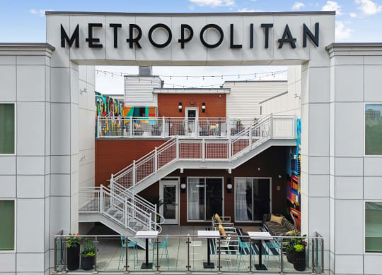 the front of a metropolonica building with tables and chairs