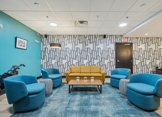 a waiting room with blue chairs and a yellow couch