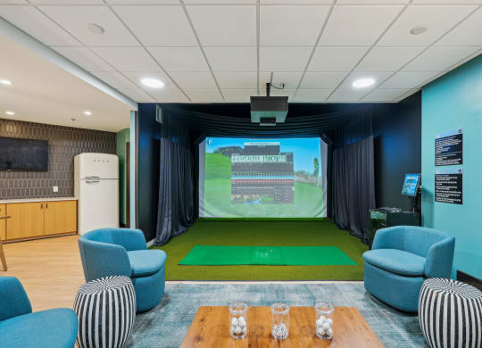 a room with a projector screen and chairs and a table