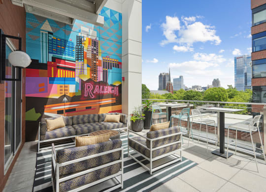 a terrace with couches and a table and a mural on the wall