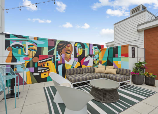 a mural on the side of a building with a couch and table