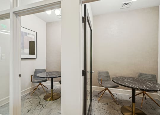 a meeting room with a table and chairs and a glass door