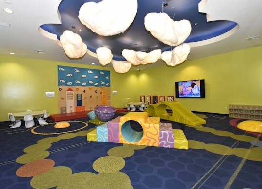 Childrens playroom with soft play equipment and cloud lighting at Casa Mira View Apartments, San Diego