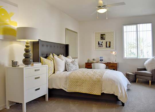 Bedroom with dark upholstered headboard and white bedding at Casa Mira View Apartments, San Diego