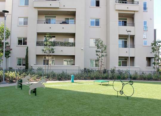 Courtyard playground with green space and apartment views at Casa Mira View Apartments, California