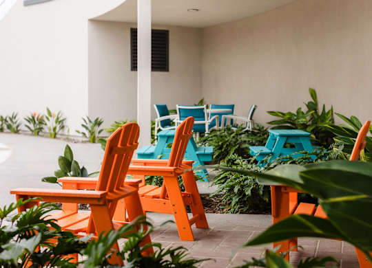 Outdoor patio with colorful adirondack chairs and greenery at Casa Mira View Apartments, San Diego, CA
