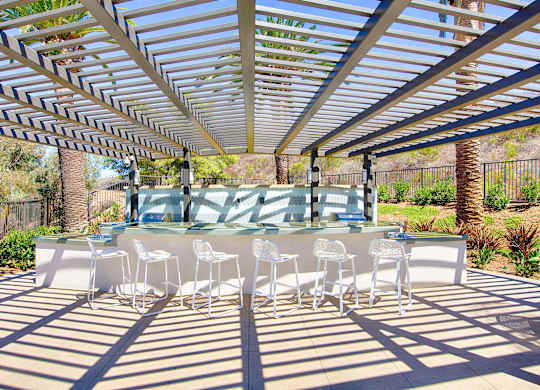 Outdoor dining area with pergola and seating at Casa Mira View Apartments, San Diego