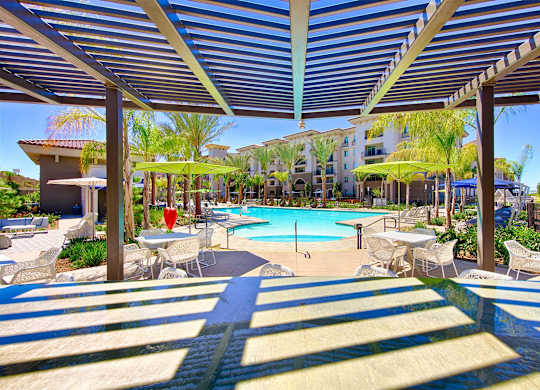 Pergola covered patio overlooking resort pool area at Casa Mira View Apartments, California