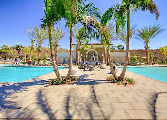 Pool courtyard with circular fountain sculpture and palms at Casa Mira View Apartments, San Diego
