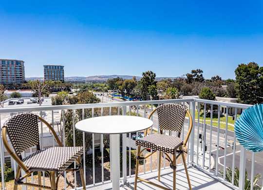 Private balcony with bistro table and chairs at Elements Apartments, Irvine, CA