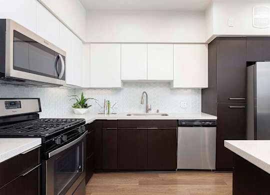 Contemporary kitchen with dark and white cabinets at Elements Apartments, Irvine, California