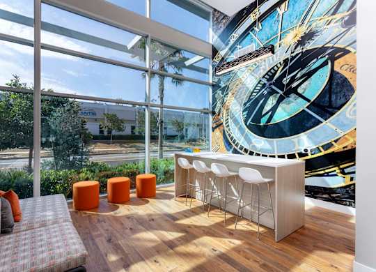Lobby lounge with bar seating and large windows at Elements Apartments, Irvine, 92612