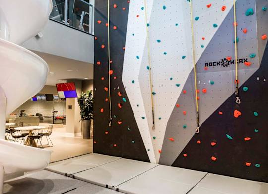 Indoor rock climbing wall with colorful holds at Elements Apartments, Irvine, CA 92612