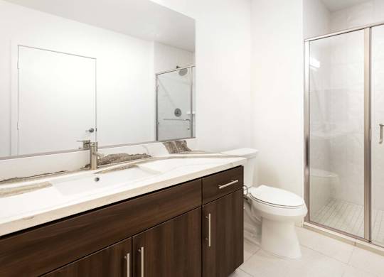 Bathroom with walk in shower and dual sink vanity at Elements Apartments, Irvine, CA