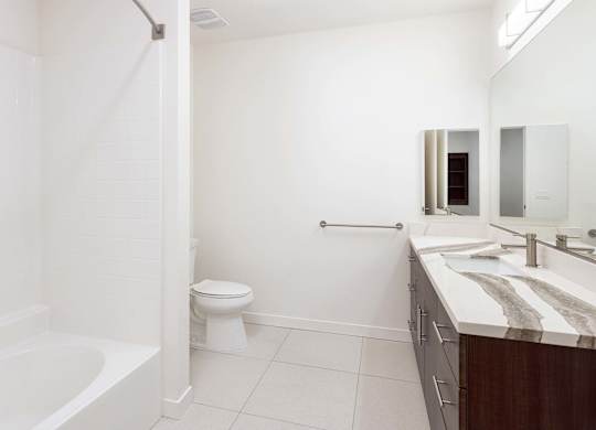 Modern bathroom with tub shower combo and double vanity at Elements Apartments, Irvine, CA 92612