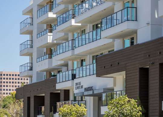 White modern building facade with cantilevered balconies at Elements Apartments, California