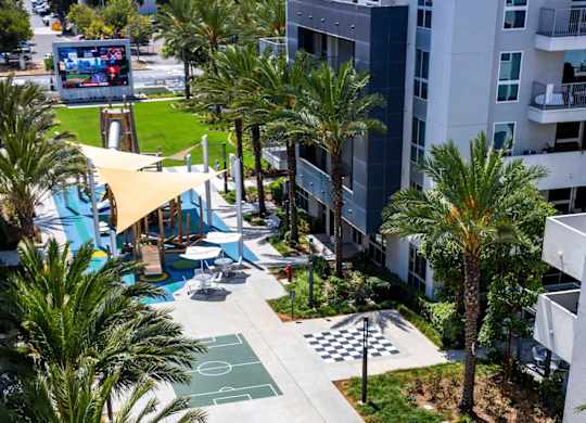 Aerial view of courtyard with basketball court and palm trees at Elements Apartments, California