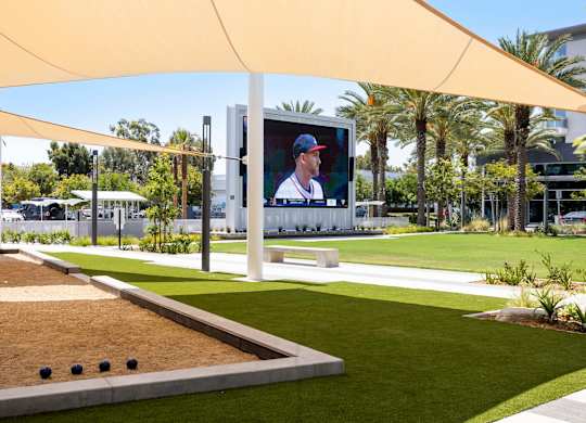 Bocce ball court with shade sails and large screen at Elements Apartments, Irvine, 92612