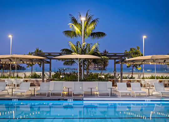 Resort style pool with cabanas at twilight at Elements Apartments, Irvine, California