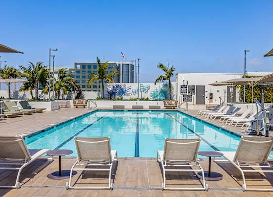 Rooftop swimming pool with lounge seating and murals at Elements Apartments, Irvine, 92612