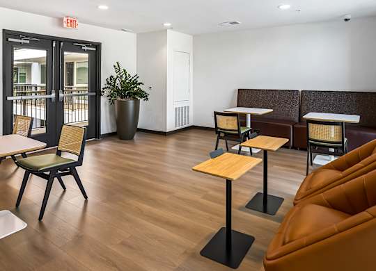 Coworking lounge with side tables and booth seating at Elements Apartments, California