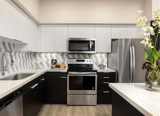 Contemporary kitchen with chevron tile backsplash at LUX by Garden* Apartments, San Diego, CA 92122