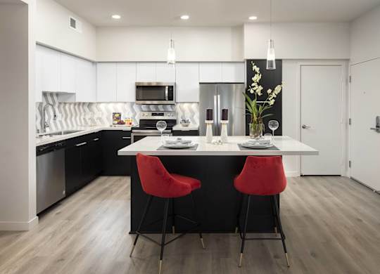 Contemporary kitchen with island and bar seating at LUX by Garden* Apartments, San Diego, CA
