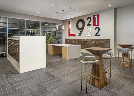 Modern lobby with mailboxes and high top seating at LUX by Garden* Apartments, San Diego, California