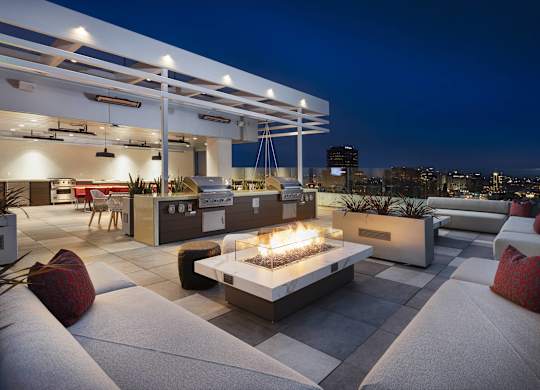 Rooftop terrace with fireplace and city skyline views at LUX by Garden* Apartments, San Diego, CA