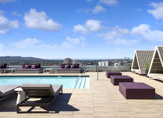 Rooftop pool deck with cabanas and purple loungers at LUX by Garden* Apartments, San Diego, CA 92122