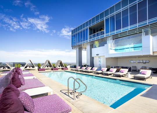 Rooftop pool with cabanas and glass sky deck at LUX by Garden* Apartments, San Diego, CA